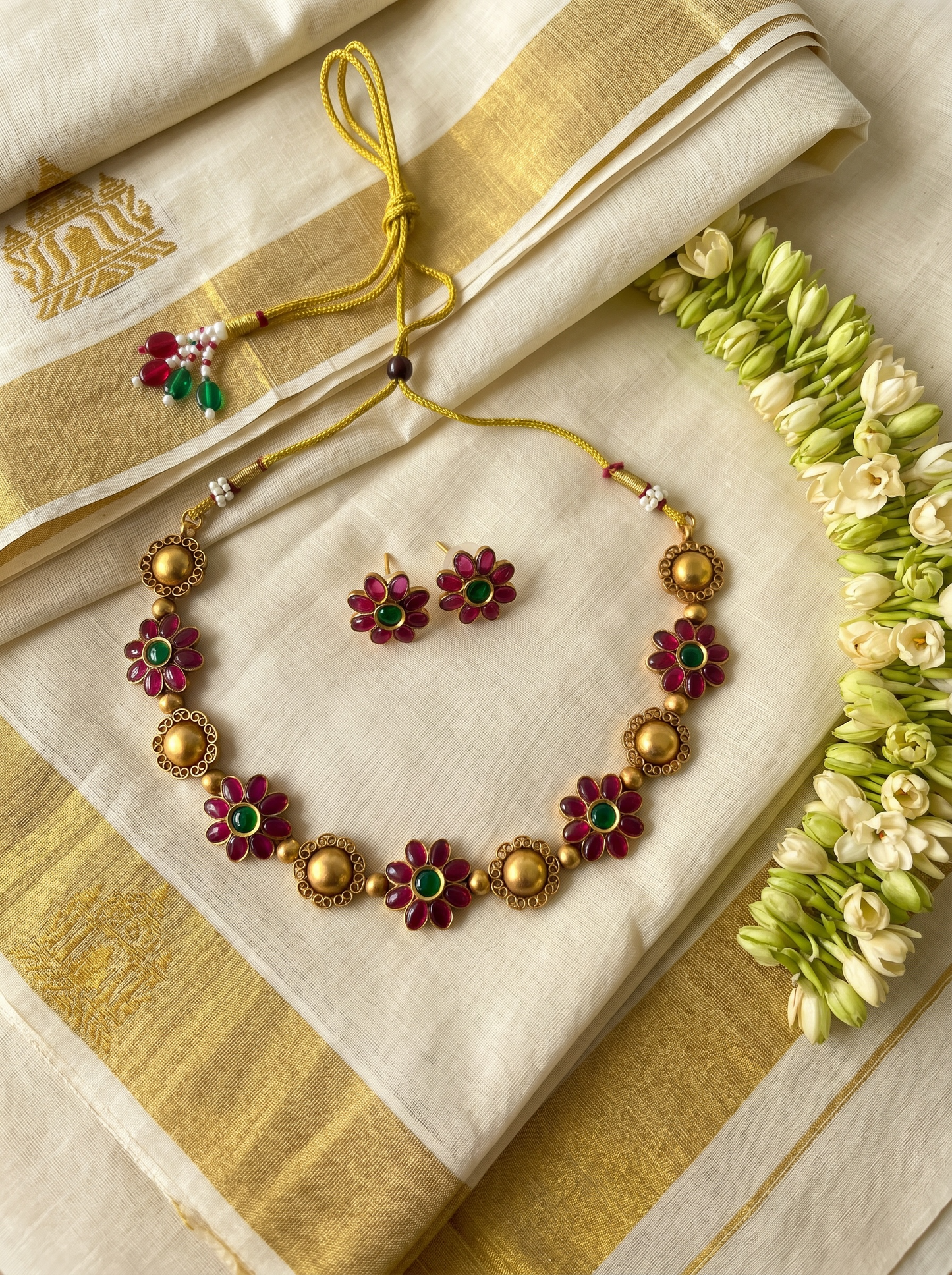 Floral Ruby Emerald Necklace Set with ornate circular flower pendants in vibrant ruby and emerald tones, featuring traditional filigree work and bold chain link design