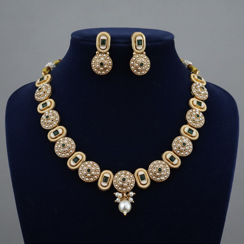 Liora By Leony antique gold necklace set with pearl and emerald accents, featuring circular motifs and a pearl drop pendant.