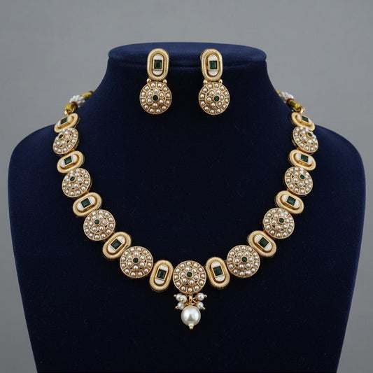 Liora By Leony antique gold necklace set with pearl and emerald accents, featuring circular motifs and a pearl drop pendant.