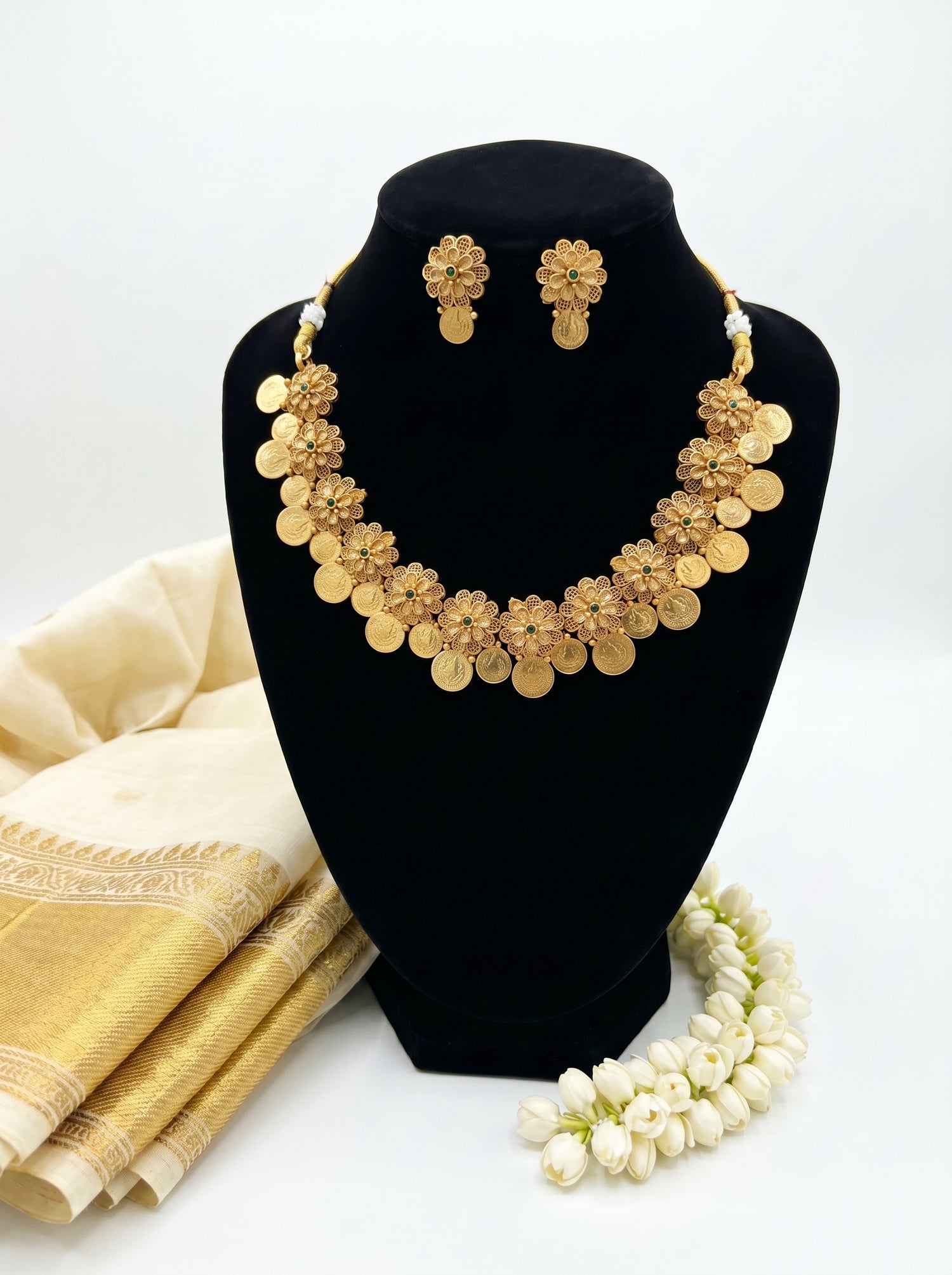 Liora By Leony gold-tone floral coin necklace with matching earrings, featuring green stone accents.