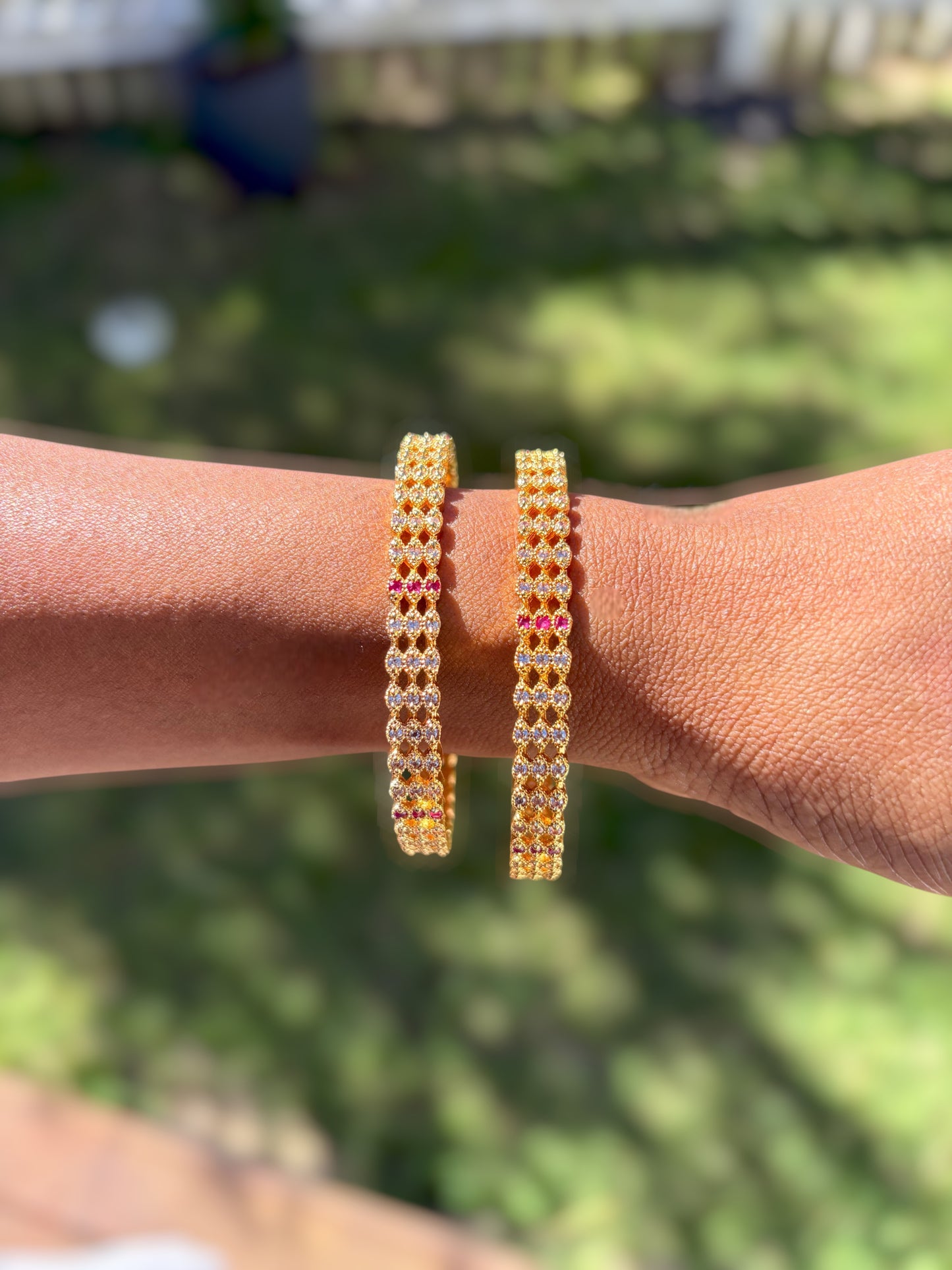 Liora By Leony Jaal Kundan Bangles pair, gold-tone with clear and pink stones in lattice pattern.